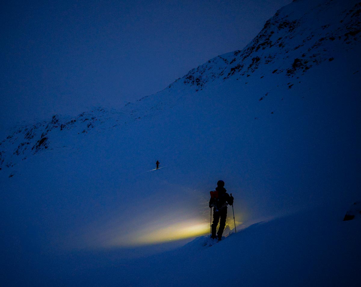 descente à ski de nuit depuis le col du blanchet, ombres de skieurs et lumières frontales