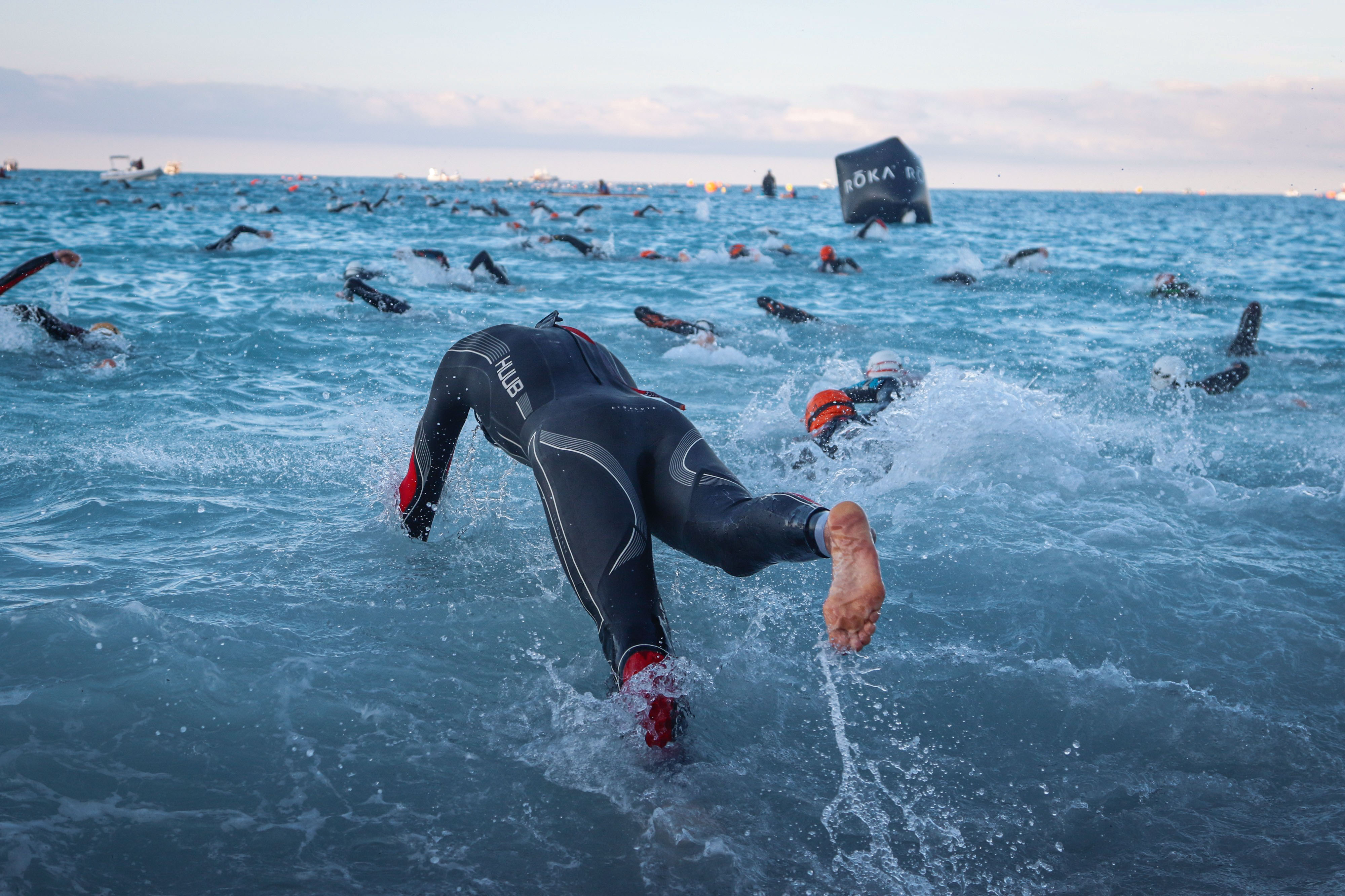 Départ de l'ironman, personne en combinaison noir qui plonge dans l'eau