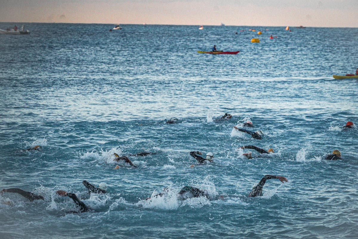 Une trantaine d'athlètes nageant dans la mer à l'occasion de l'ironman de Nice 2024