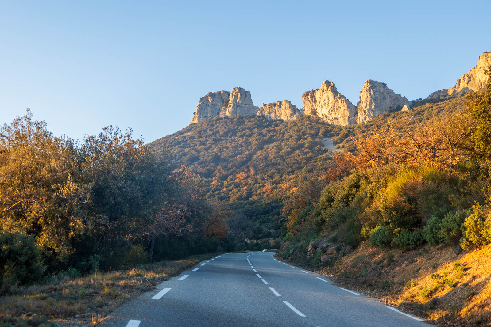 haut du col de l'espigoulier, route menant à un éperon rocheux dans une végétation aux couleurs printanières 